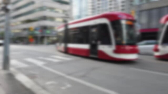 Modern trams, skyscrapers, streets and pedestrian crossing in downtown Toronto, Ontario, Canada. Out of focus.