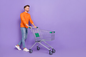 Full size photo of good mood shopaholic male go shopping in city center mall isolated on purple...