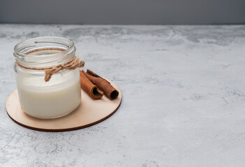 Vegetarian milk and cinnamon sticks on wooden board. Alternative drinks for autumn, fall season. Organic homemade food. Non lactose.