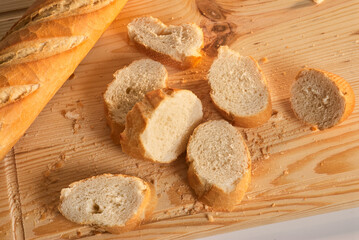 Bread slices on a wooden board with crumbs around