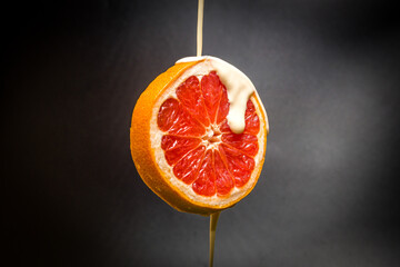 Fresh grapefruit with water yogurt drops. isolated dark background