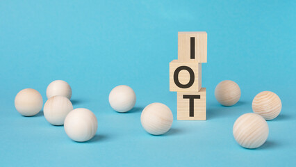 IOT - Internet of Things - text on wooden block with bright blue background