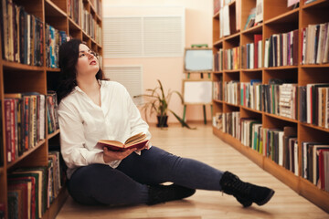 Portrait of young  plus size girl posing in library