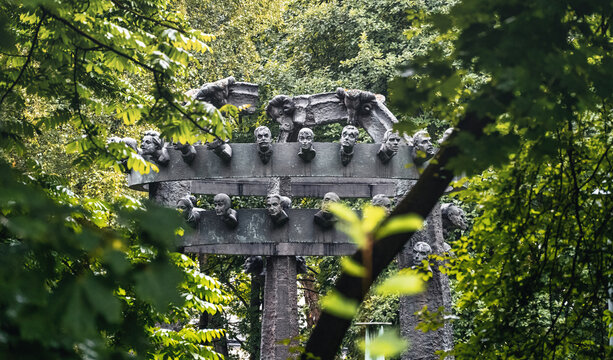 Bronislaw Chromy Gallery Monument with several human faces surround with greenery or trees located in Decius park in Krakow Poland