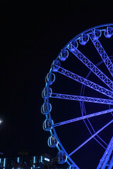 Ferries Wheel with colorful lights in dark sky, night time in amousement park