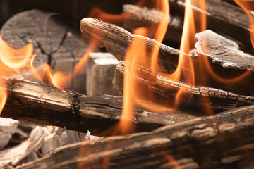 Burning wooden firewood close-up. tongues of flame. background texture fire