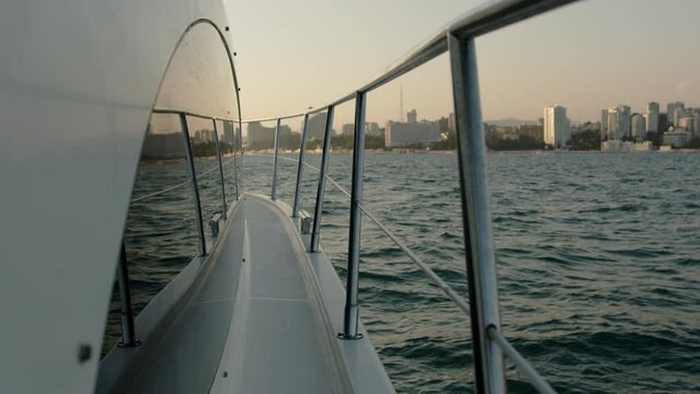 The view from the white yacht and the reflection in the windows of the city metropolis and the waves of the ocean sea