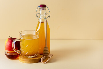 Glass Mug of Fresh Organic Apple Cider with Honey and Cinnamon Yellow Background Horizontal Copy Space