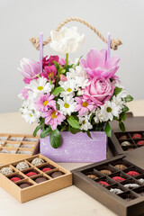 bouquet of flowers with Chocolate Box assorted. Flowers spring and Handmade chocolates candy - gift for celebration