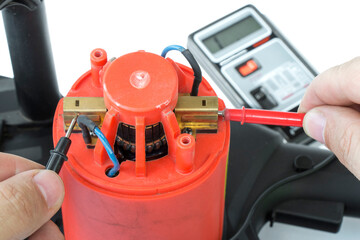 checking the operation of the armature winding of an electric motor, continuity of the electric circuit with a multimeter, close-up on a white isolated background