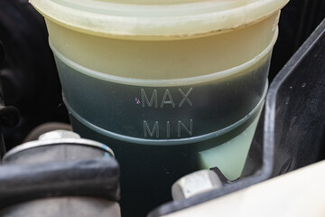 Close-up of the car's power steering fluid reservoir.