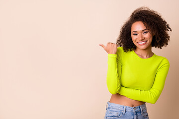 Closeup photo of young cute lady wear yellow top directing finger empty space teeth whitening isolated on beige color background