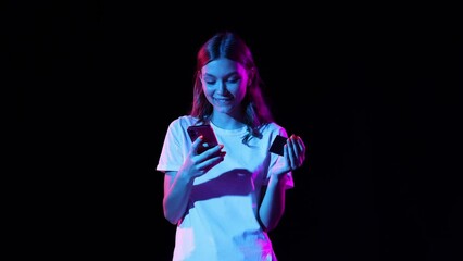 Smiling young girl pays for purchase with credit card and mobile app. Concept of business, black friday sales, discount, cyber monday and online purchases.