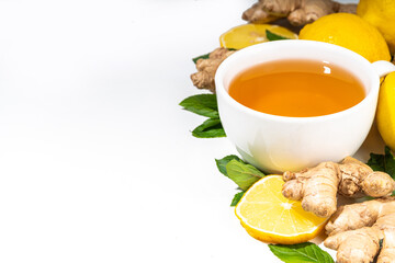 Healthy organic vegan immunity booster, herbal drink. Antioxidant anti-inflammatory ginger lemon tea with ingredient - fresh ginger, lemon, mint, white background flatlay top view copy space
