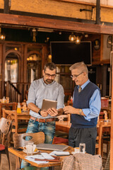 Looking at some informations on the tablet while standing in the cafe