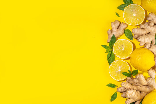 Healthy organic vegan immunity booster, herbal drink. Antioxidant anti-inflammatory ginger lemon tea with ingredient - fresh ginger, lemon, mint, bright yellow background flatlay top view copy space