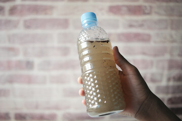 holding dirty bottle of water 