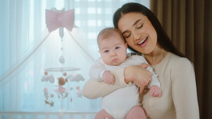 In the morning charismatic little baby girl together with her mother speeding cute time together they hugging each other concept of nursing childhood and maternity