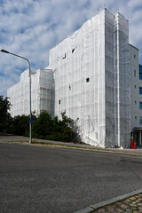 Scaffold in front of building facade covered with fabric
