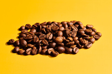 Roasted coffee beans on yellow background