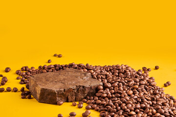 Roasted coffee beans on stone pedestal yellow background
