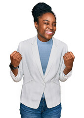 Young african american woman wearing business clothes very happy and excited doing winner gesture with arms raised, smiling and screaming for success. celebration concept.