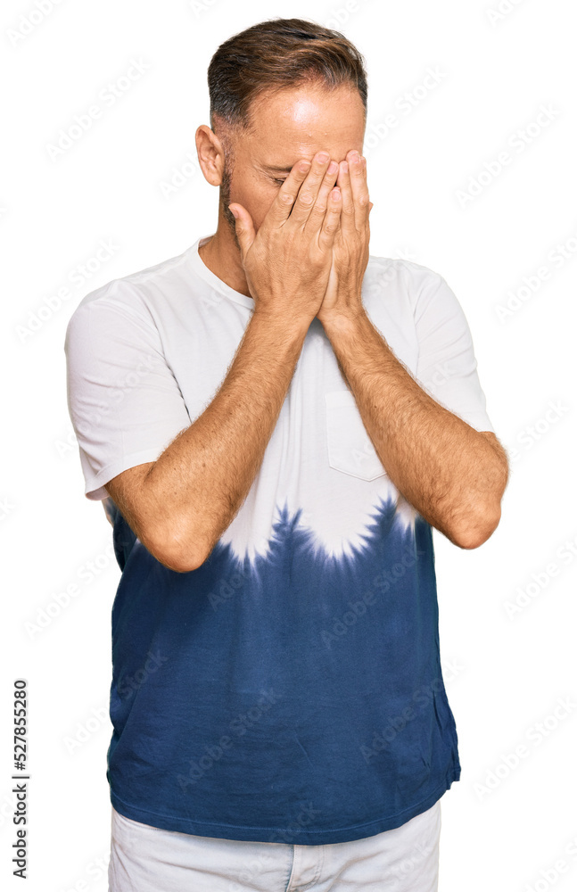 Sticker handsome middle age man wearing casual tie dye tshirt with sad expression covering face with hands w