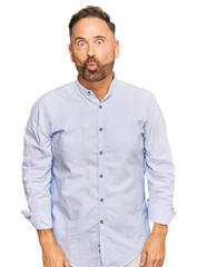 Handsome middle age man wearing business shirt making fish face with lips, crazy and comical gesture. funny expression.