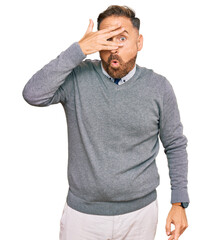 Handsome middle age man wearing business clothes peeking in shock covering face and eyes with hand, looking through fingers with embarrassed expression.