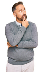 Handsome middle age man wearing business clothes with hand on chin thinking about question, pensive...