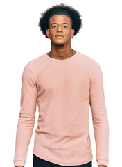 African american man with afro hair wearing casual clothes relaxed with serious expression on face. simple and natural looking at the camera.