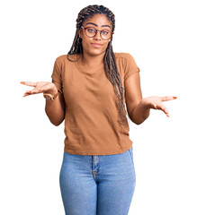 Young african american woman with braids wearing casual clothes and glasses clueless and confused...