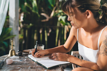 Woman write in notebook on terrace of resort hotel
