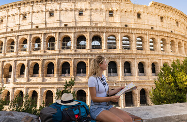 Young woman tourist searches sitting in her map for city attractions on a sunny summer day