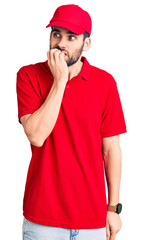 Young handsome man with beard wearing delivery uniform looking stressed and nervous with hands on mouth biting nails. anxiety problem.