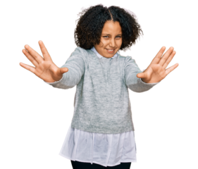 Young little girl with afro hair wearing casual clothes afraid and terrified with fear expression stop gesture with hands, shouting in shock. panic concept.