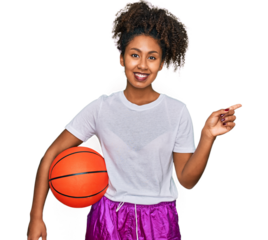 Young african american girl playing baseball holding bat and ball smiling happy pointing with hand and finger to the side