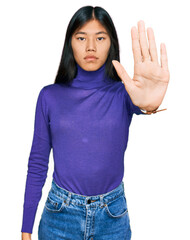Beautiful young asian woman wearing casual clothes doing stop sing with palm of the hand. warning expression with negative and serious gesture on the face.