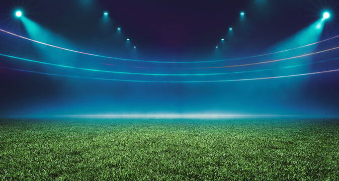 Fresh green lawn on football stadium with neon lights illumination