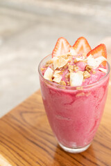 strawberry smoothie with strawberries in glass on a wooden table