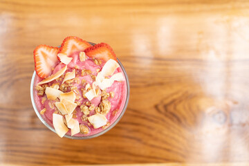 strawberry smoothie with strawberries in glass on a wooden table