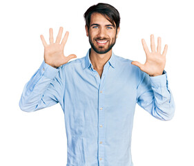 Fototapeta premium Hispanic man with blue eyes wearing business shirt showing and pointing up with fingers number ten while smiling confident and happy.