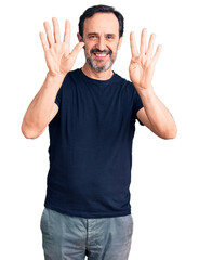 Middle age handsome man wearing casual t-shirt showing and pointing up with fingers number nine while smiling confident and happy.