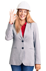 Beautiful young woman wearing architect hardhat smiling positive doing ok sign with hand and fingers. successful expression.