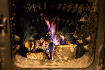 Burning wood in the old heating stove in the house.