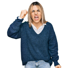 Young caucasian woman wearing casual clothes angry and mad raising fist frustrated and furious while shouting with anger. rage and aggressive concept.