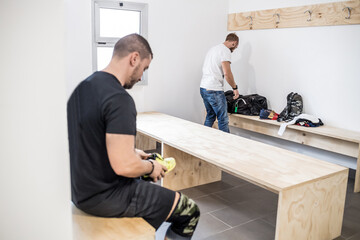 Two sportive athletic men gym locker room changing