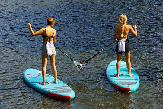 Zwei junge Frauen beim stand-up-paddling 