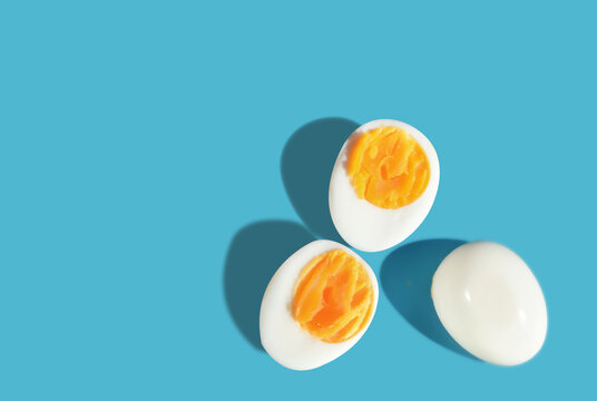 Boiled eggs slice with shadow on blue background with sunlight. Copy space concept and torether idea