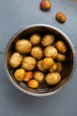 Top view of raw potaoes roots in bowl with water cooking concept food
